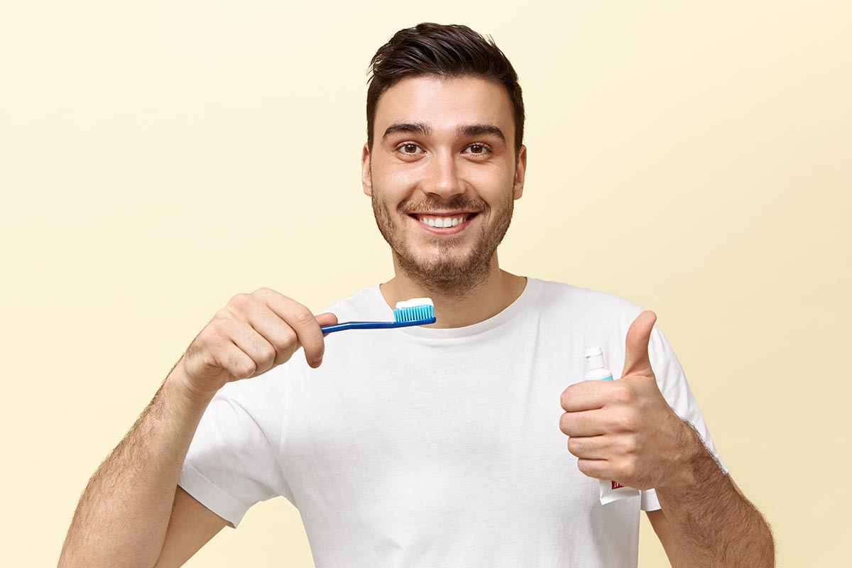 happy-energetic-young-man-using-brush-toothpaste-dental-blog-dental-resolution-2021